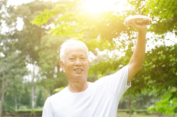 Asian old man playing dumbbell in the park — Stock Photo, Image