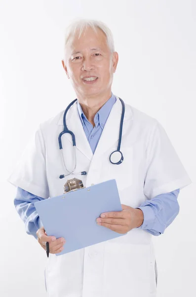 Médico asiático sênior segurando relatório de saúde — Fotografia de Stock