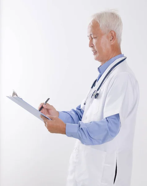 Senior Asian lekarza pisania raportu — Zdjęcie stockowe