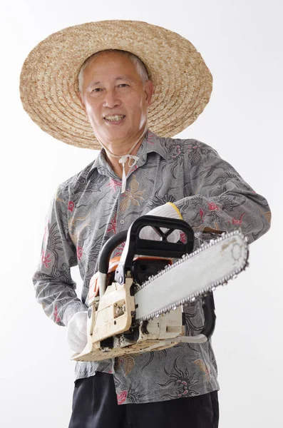 Asyalı yaşlı adam holding chainsaw — Stok fotoğraf