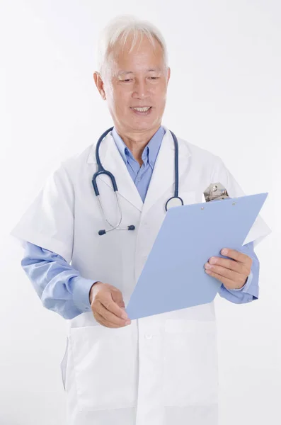 Old Asian medical doctor reading report Stock Picture