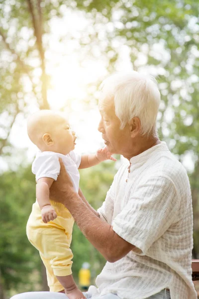 Nonno con nipote seduto alla panchina all'aperto . — Foto Stock