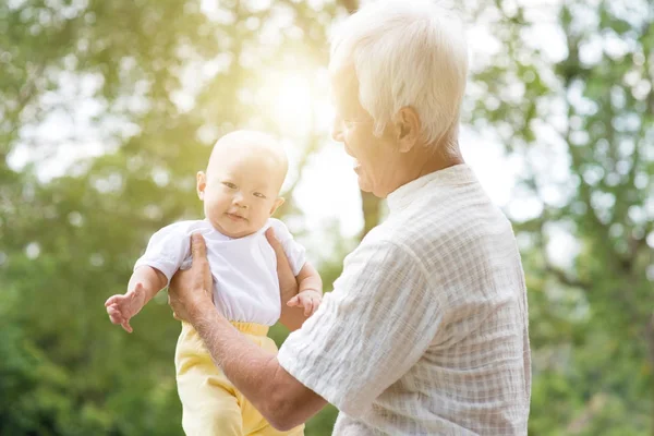 Бабушка с дедушкой и внучка в открытом парке . — стоковое фото