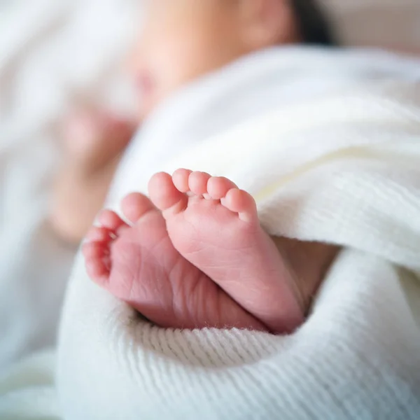 Nyfödda babyfötter i sängen — Stockfoto