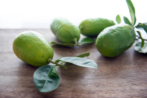 Limones verdes orgánicos frescos con hojas —  Fotos de Stock