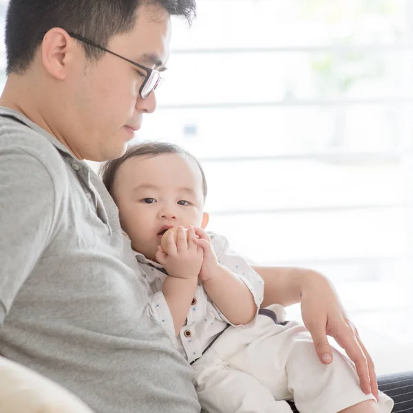 Pai e bebê sentados no sofá . — Fotografia de Stock