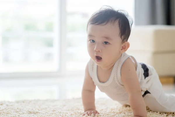 Lindo bebé niño arrastrándose en la alfombra . — Foto de Stock