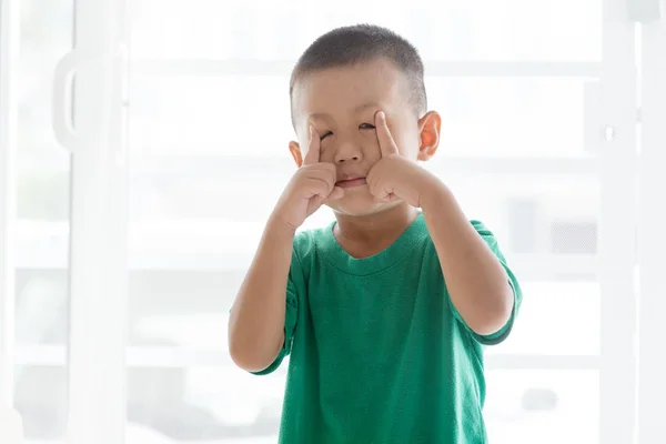 Brincalhão menino puxando rosto — Fotografia de Stock