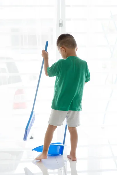 Asian boy sweeping floor — Stock Photo, Image
