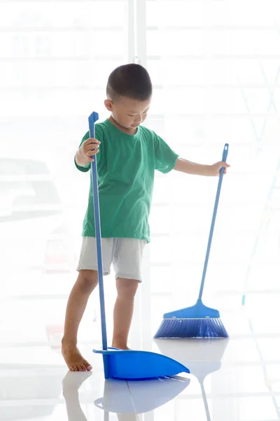 Asian child sweeping floor — Stock Photo, Image