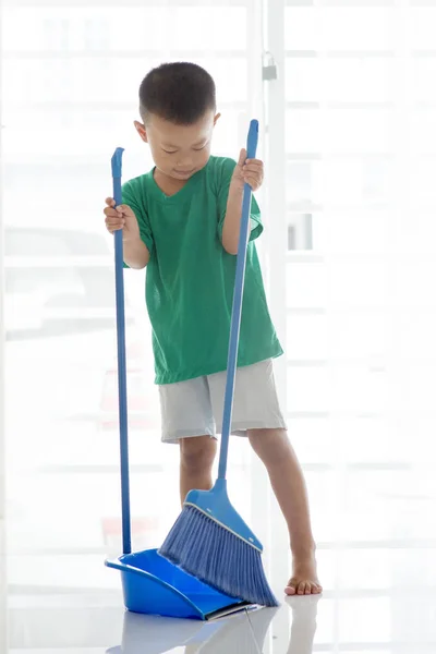 Young boy sweeping floor — Stock Photo, Image