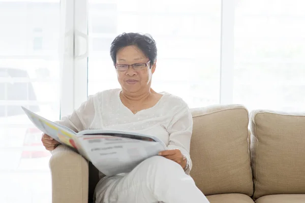 Asiática senior mujer leyendo periódico — Foto de Stock