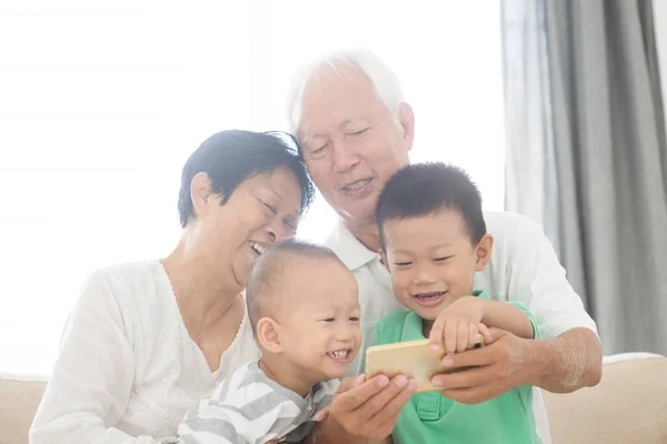 Far-och morföräldrar och barnbarn tar selfie med smarta telefoner — Stockfoto