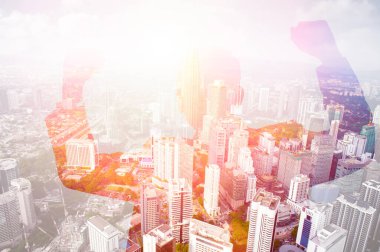 Heyecanlı bir iş adamının başarıyı şehir manzarası ile üst üste kutlarken çifte pozlama görüntüsü. 