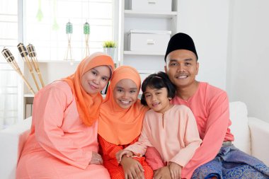 Hari Raya zamanındaki geleneksel kıyafetlerle mutlu Malay aile portreleri. Malezyalı aile yaşam tarzı.