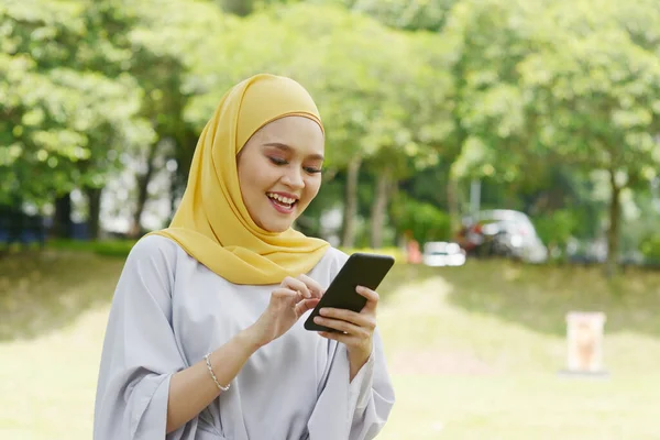 Портрет Веселої Мусульманської Дівчини Яка Користується Смартфоном Усміхається Вулиці — стокове фото