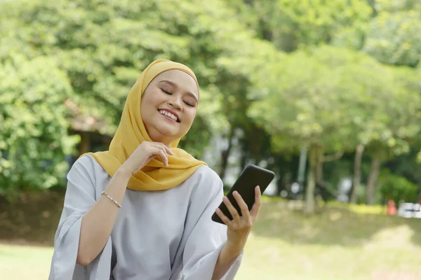 Portret Van Vrolijk Moslim Meisje Met Smartphone Glimlachend Naar Buiten — Stockfoto