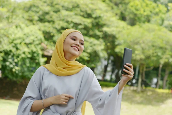 Portret Van Vrolijk Moslim Meisje Met Smartphone Glimlachend Naar Buiten — Stockfoto