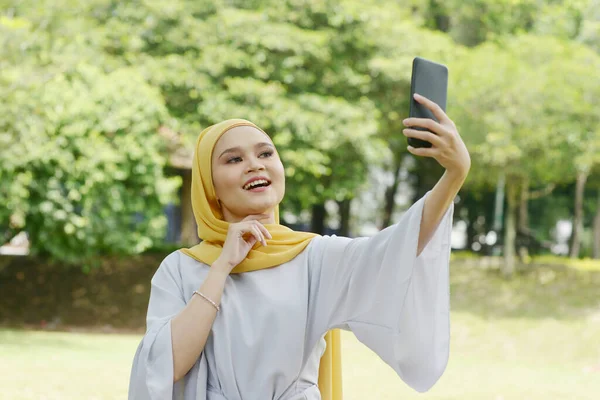 Portret Van Vrolijk Moslim Meisje Met Smartphone Glimlachend Naar Buiten — Stockfoto