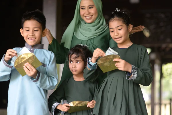 イスラム教徒の家族 子供たちは祝福としてお金のパケットを受け取りました Hari Raya Eid Fitrの概念 — ストック写真