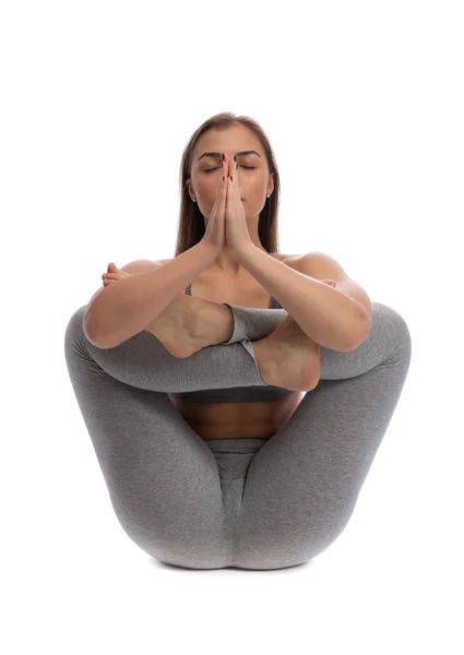 Mujer practicando yoga en un estudio sobre fondo blanco — Foto de Stock