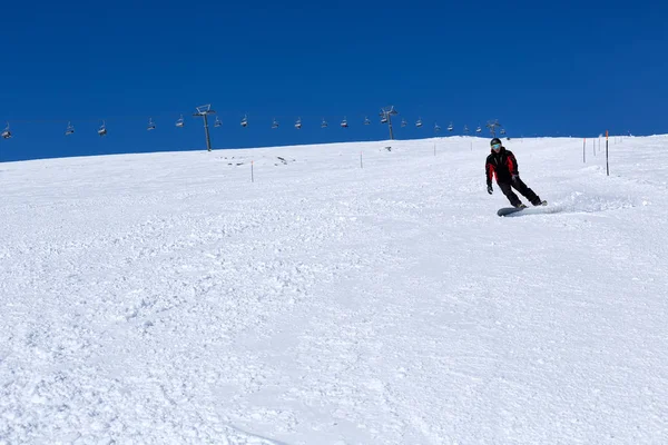 Muž na snowboardu na úbočí hory — Stock fotografie