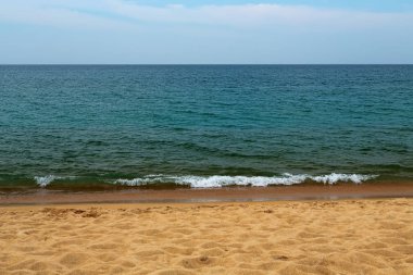 Kumlu sahilde yumuşak bir mavi okyanus dalgası. Arkaplan.