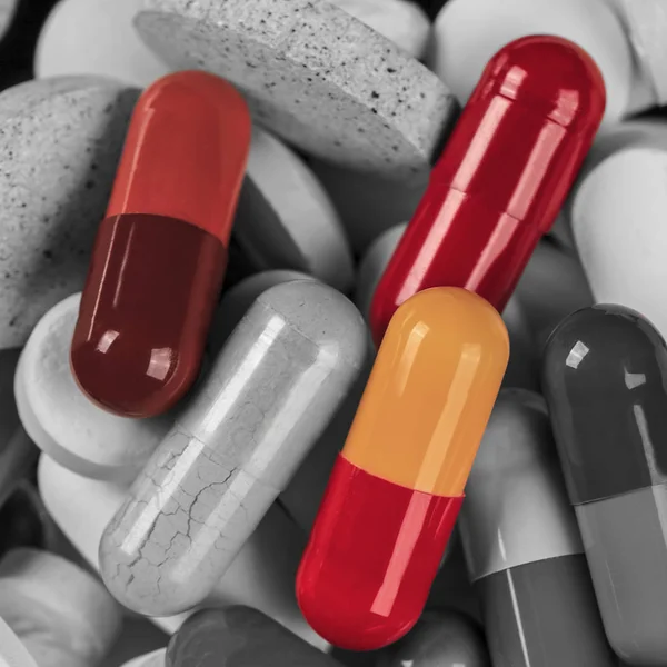 S & w Haufen Medikamentenpillen mit isolierten farbigen Pillen. — Stockfoto