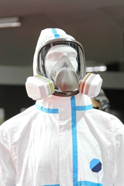 Tehlikeli madde giysisi ve çift hava filtresi olan koruyucu maske.