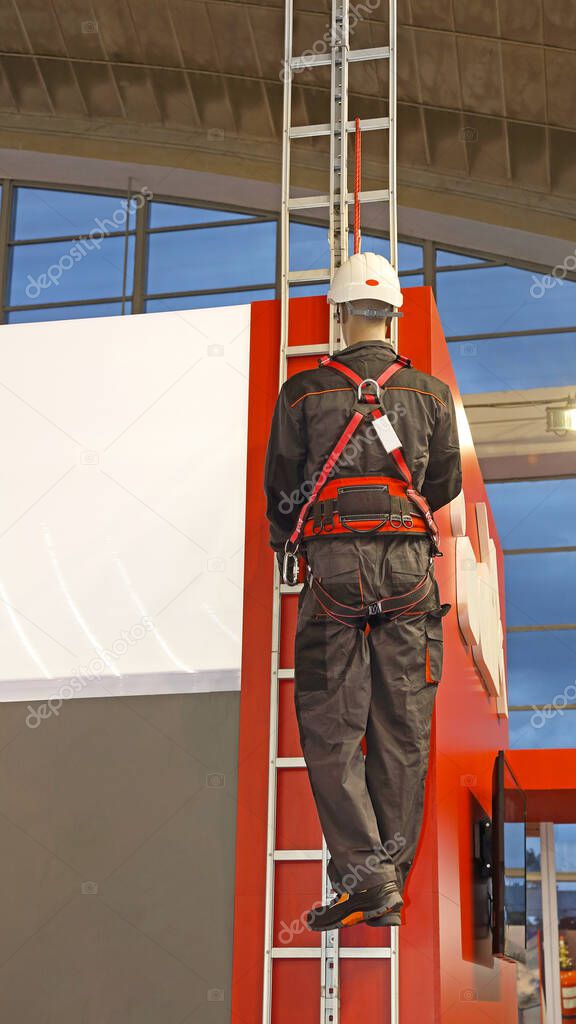 Worker on a Ladder With Safety Harness Protection