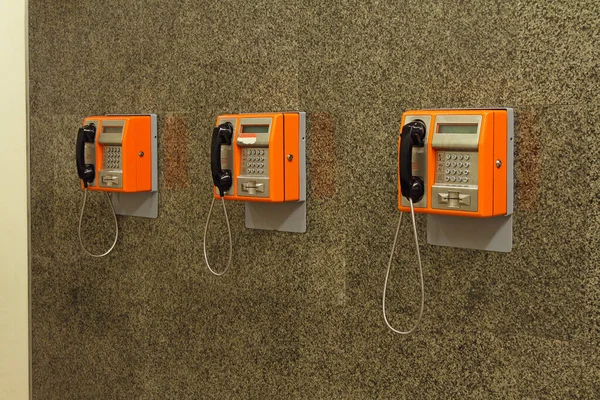 Tre Orange Retro Offentliga Telefoner Vid Muren — Stockfoto