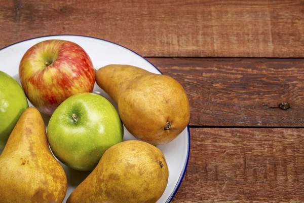 Appelen en peren op rustieke houten tafel — Stockfoto
