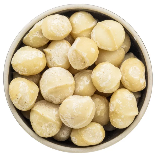 Орехи макадамии в изолированной миске — стоковое фото