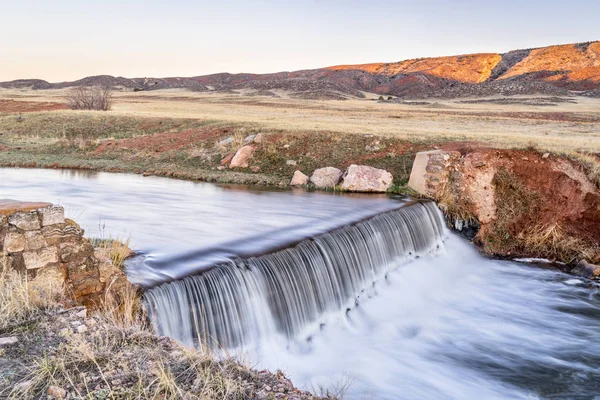 Water trapsgewijs over een dam — Stockfoto