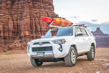 Toyota 4runner Suv bir çöl izinde çatıda bir kayık ile