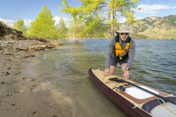 Senior-Paddler mit Expeditions-Stand Up Paddleboard — Stockfoto