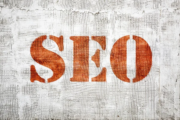 垃圾灰泥纹理墙上画的 Seo 标志 — 图库照片