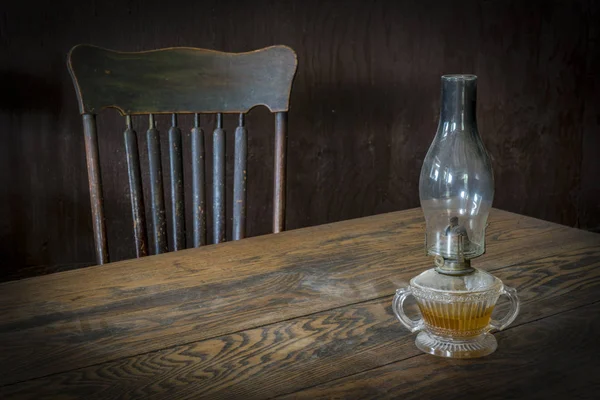 Vintage oil lamp on dusty table — Stock Photo, Image