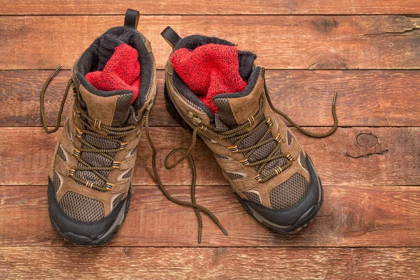 Oude zware wandelen laarzen agains hout — Stockfoto