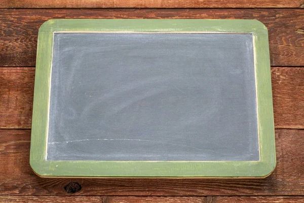 Tom skiffer blackboard mot rustikt trä — Stockfoto