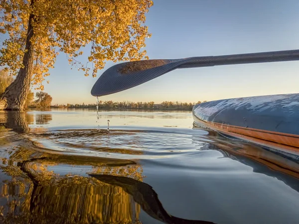 Stand up paddleboard on lake with fall colors — Stock Photo, Image