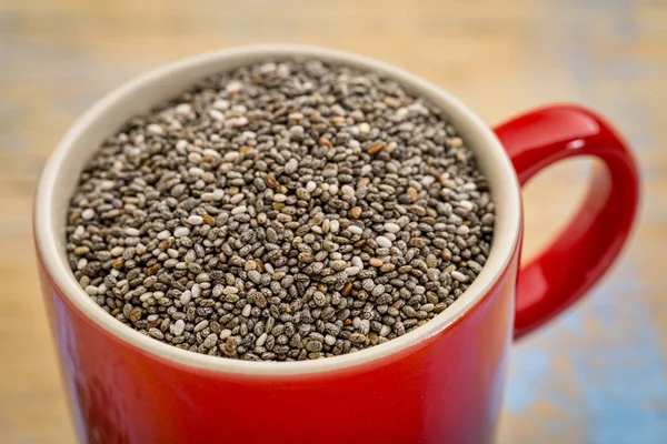 Μαύρο chia σπόρους σε ένα φλιτζάνι καφέ — Φωτογραφία Αρχείου
