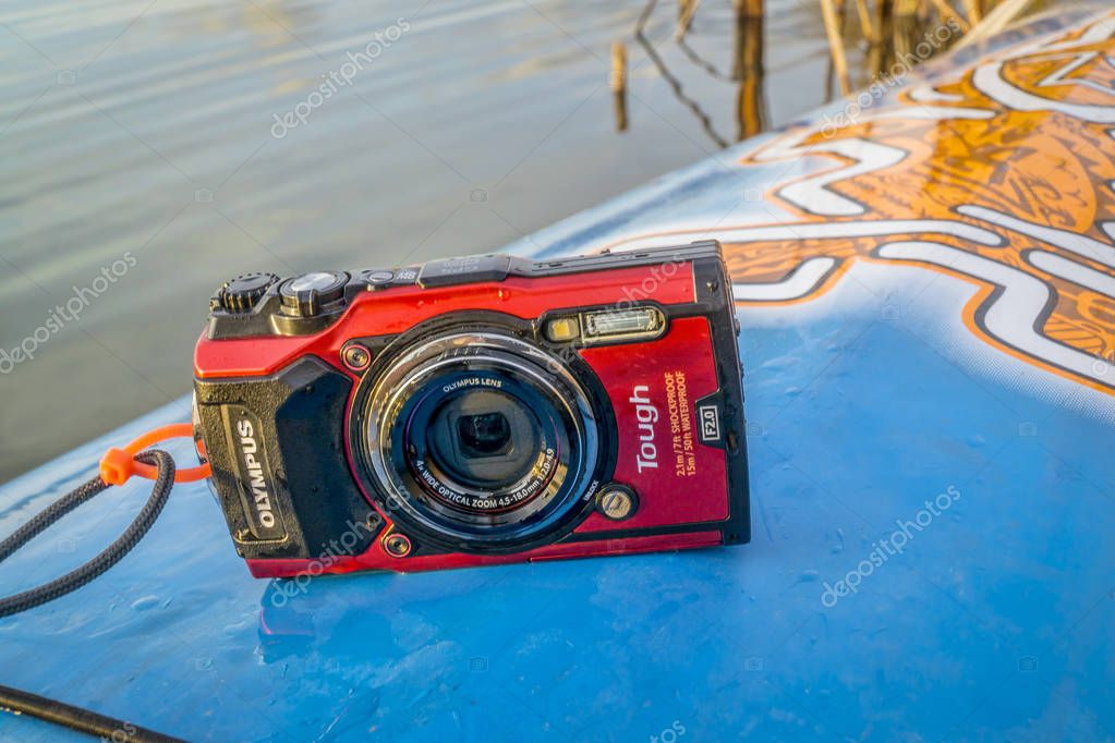 Fort Collins, CO, USA - October 23, 2017: Compact, waterproof Olympus Stylus Tough TG-5 camera on a wet deck of a stand up paddleboard by Starboard.