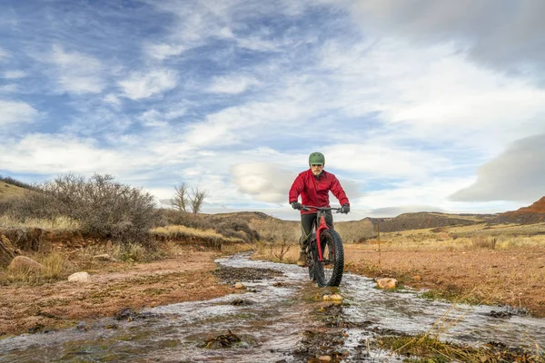 Montar una bicicleta gorda a través de un arroyo — Foto de Stock