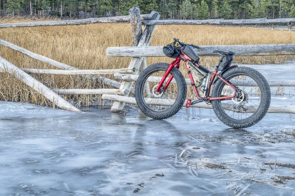 ロッキー山脈の氷のようなストリームに脂肪の自転車 — ストック写真