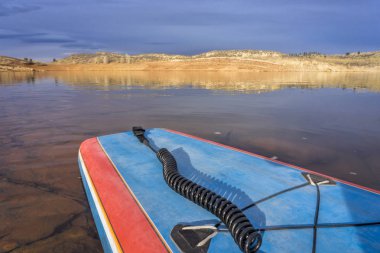 Sakin göl kenarında paddleboard ayağa 
