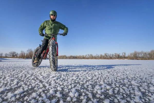 Fat bike cyklist på en frusen sjö i vinter — Stockfoto