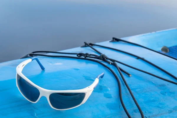 Sport solglasögon på stand up paddleboard — Stockfoto