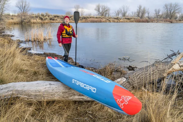 Carreras de pie paddleboard en un lago tranquilo —  Fotos de Stock