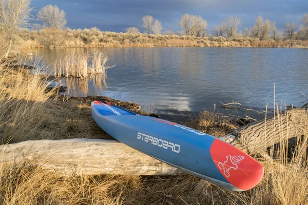Carreras de pie paddleboard en un lago tranquilo — Foto de Stock